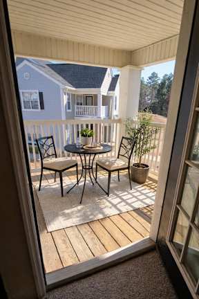A patio with a table and chairs is visible through a doorway.