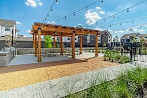 a pergola sits in the middle of a park with a playground in the background