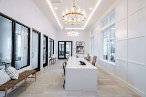 a long white reception desk with a chandelier hanging above it