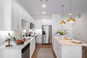 a kitchen with white cabinets and stainless steel appliances