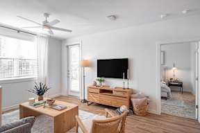 a living room with a tv on the wall and a table and chairs in the foreground