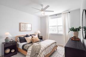 a bedroom with a bed and a ceiling fan