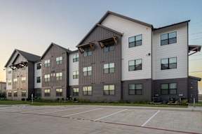 a large apartment building with a parking lot in front of it