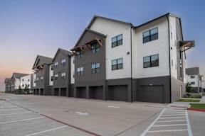 a row of apartment buildings with garages in front of them