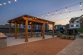a patio with a pergola and string lights