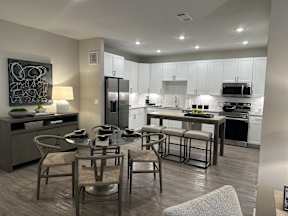 A modern kitchen with a dining table set for four.