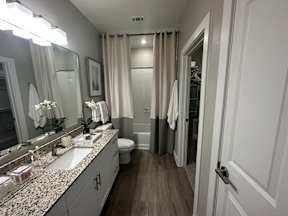 A bathroom with a toilet, sink, and mirror.