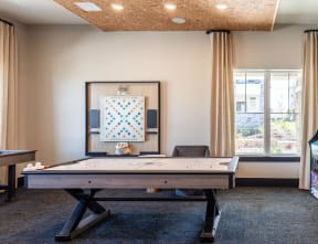 a game room with a foosball table and a painting on the wall