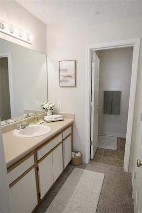 A bathroom with a sink, mirror, and towel.