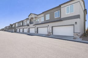 A row of houses with garages and driveways.