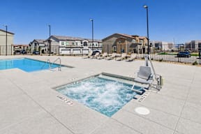 A small pool with a slide in the middle of a concrete patio.