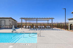 A pool with a wooden pergola and lounge chairs.