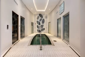 a swimming pool in the middle of a room with glass doors