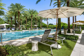 a swimming pool with lounge chairs and an umbrella