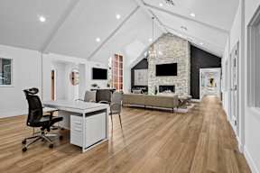 an open living room with a desk and a fireplace