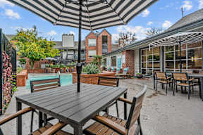 an outdoor patio with tables and chairs and a pool
