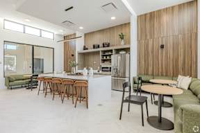 A modern kitchen and dining area with wooden cabinets and a white countertop.