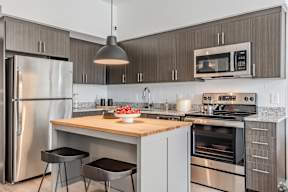 A modern kitchen with a wooden island and stainless steel appliances.