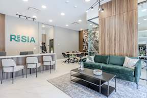 A modern office space with a green sofa and a white desk.