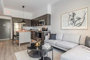 A modern kitchen with a grey couch and a coffee table.