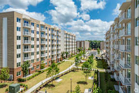 A view of a residential area with apartment buildings and a green lawn.