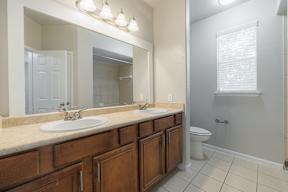 an empty bathroom with two sinks and a toilet
