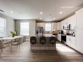 A modern kitchen with a dining table and chairs.