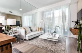 A modern living room with a white sofa and a glass table.