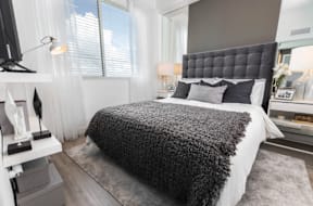 A modern bedroom with a large bed and a television.