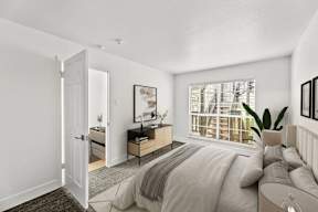 A bedroom with a large bed and a window with blinds.