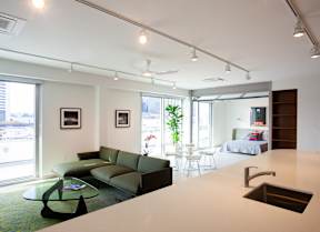 A modern living room with a green couch and a glass coffee table.