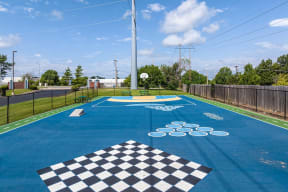 a basketball court in a park with a basketball hoop on the ground