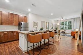 A kitchen with wooden floors and white cabinets.