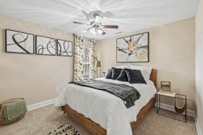 A bedroom with a large bed and a ceiling fan.