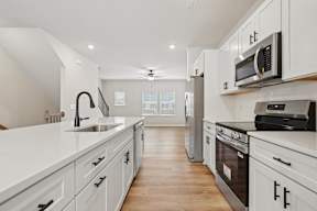 A modern kitchen with white cabinets and stainless steel appliances.