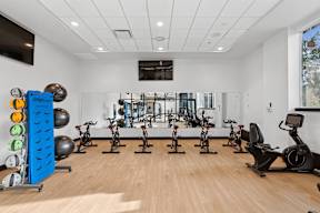 A gym with exercise equipment and a mirror on the wall.