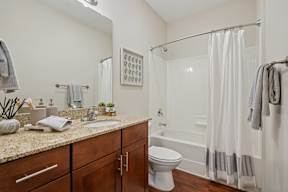 A bathroom with a toilet, sink, and shower.
