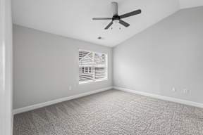 A room with a ceiling fan and carpeted floor.