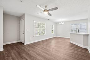 A room with a ceiling fan and wooden flooring.