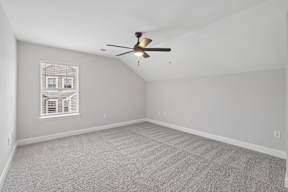 A room with a ceiling fan and carpeted floor.