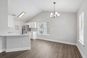 A kitchen with a white island and wooden floors.