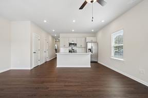 A kitchen with white cabinets and a wooden floor.