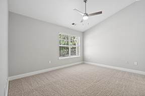 A room with a ceiling fan and a window with blinds.