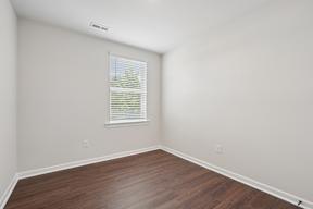 A room with a window and wooden flooring.