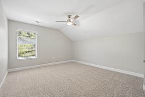 A room with a ceiling fan and a window with blinds.