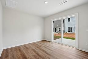A room with a sliding glass door leading to a backyard.