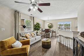 A living room with a yellow chair and a grey couch.