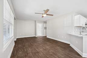 A room with a ceiling fan and wooden flooring.