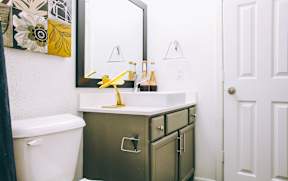 a bathroom with a white toilet and a sink and a mirror