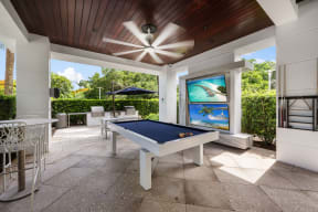 a patio with a pool table and a ceiling fan
